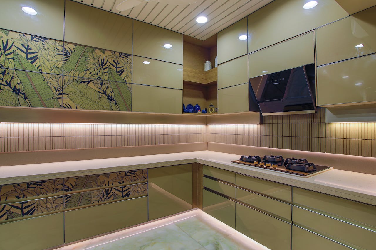 Sleek kitchen design featuring green cabinets, hob, and floral accents.