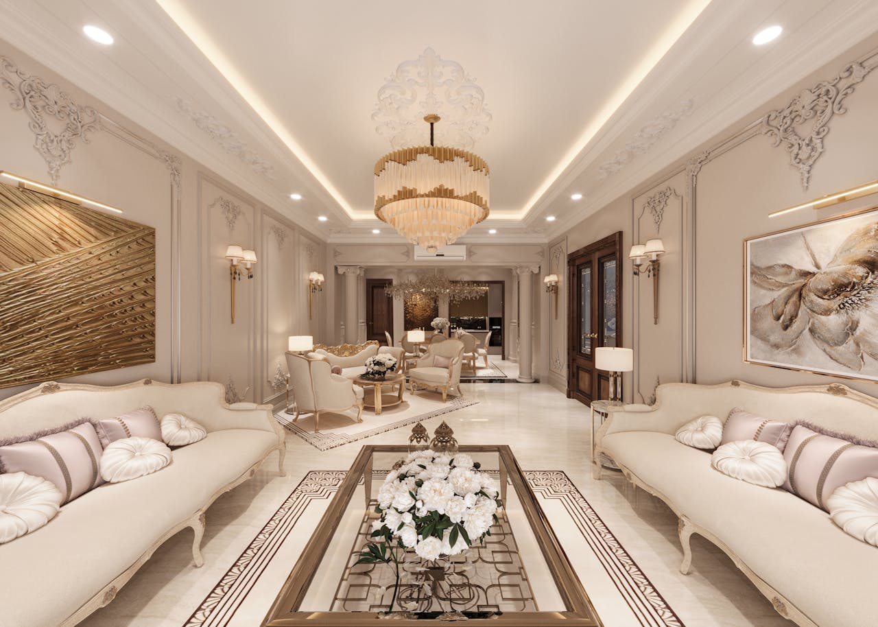 gallery-2 A beautifully decorated living room showcasing elegant interior design with sofas and a chandelier.